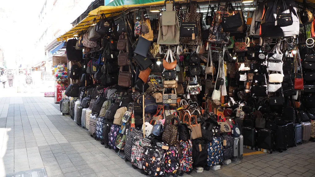 Rows of handbags, backpacks and suitcases stacked outside a shop in Gukje Market in Busan