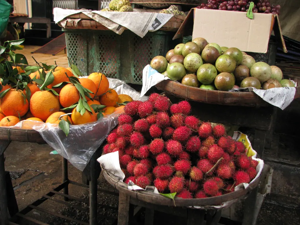Rambutans, oranges and star apples piled in baskets at a market in Vietnam