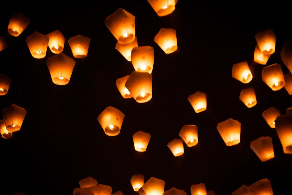 Glowing paper sky lanterns rising into the night sky at the Pingxi Lantern Festival