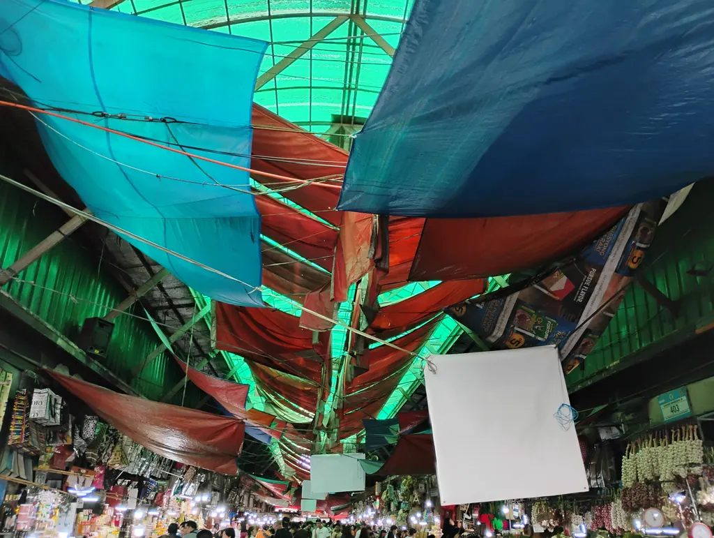 Shoppers and stalls under colorful awnings at the Baguio City Public Market