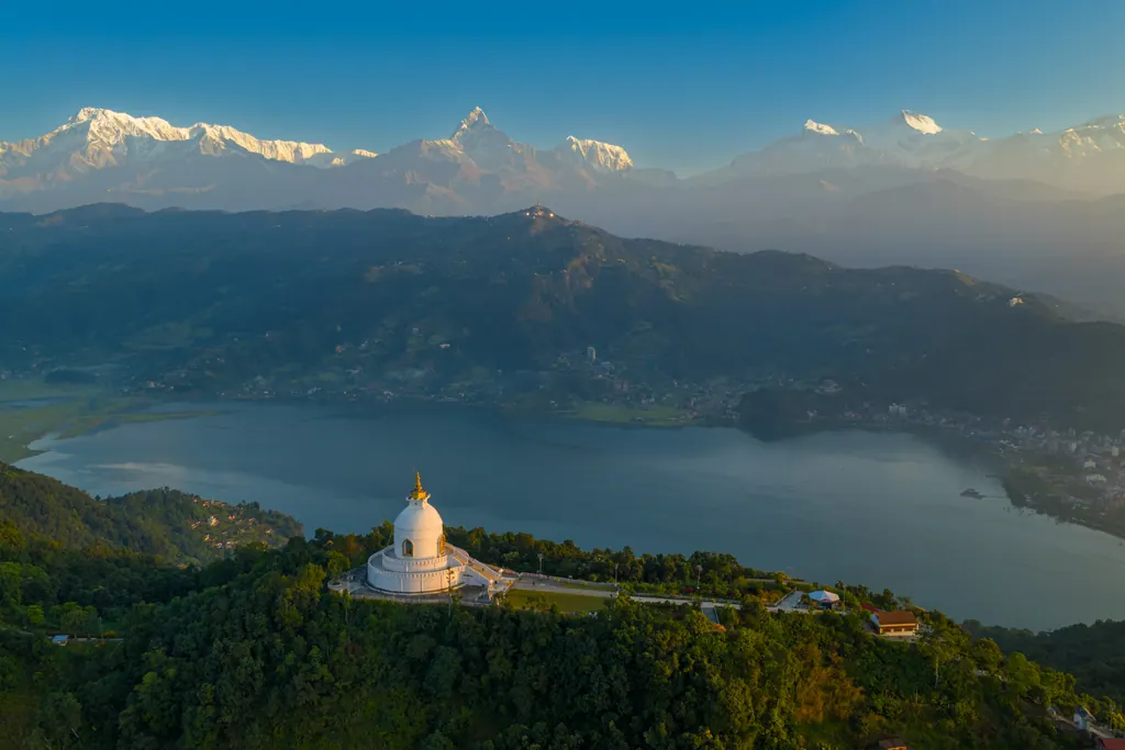 The World Peace Pagoda above Phewa Lake at sunrise with the Annapurna range and Machhapuchhre behind