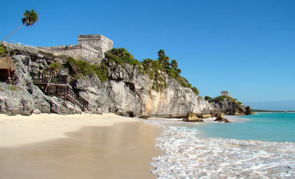 The clifftop ruins of Tulum above a white sand beach and the turquoise Caribbean Sea