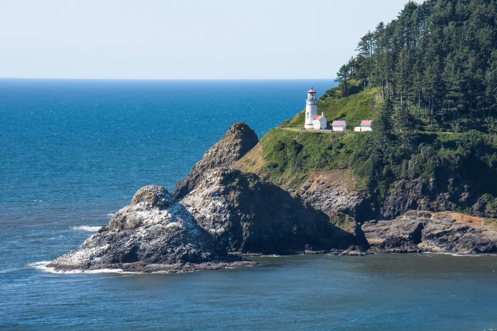 Heceta Head Lighthouse on its green headland above the blue Pacific Ocean
