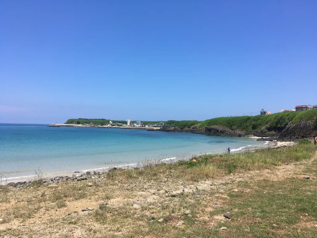 A calm turquoise bay and sandy beach in Penghu on a sunny day