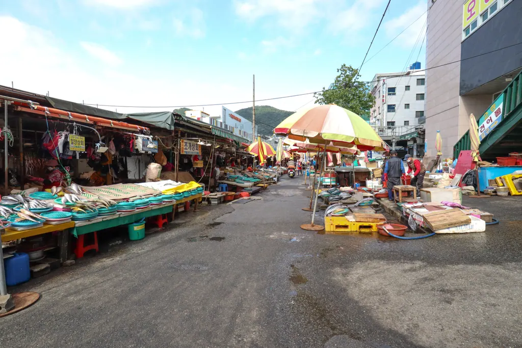 Seafood stalls under umbrellas along the waterfront at Jagalchi Market in Busan