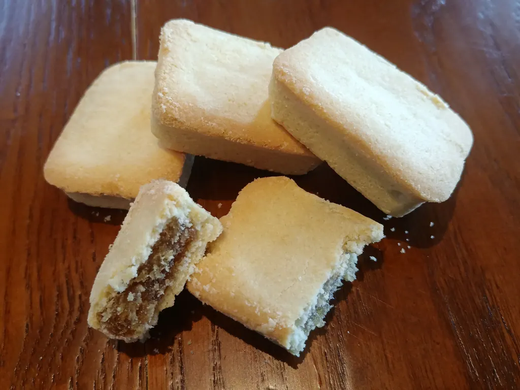 Square Taiwanese pineapple cakes, one broken open to show the filling