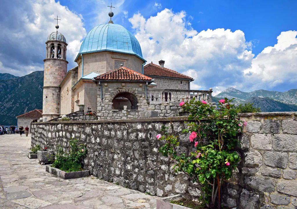 The blue-domed church of Our Lady of the Rocks on its small island in the Bay of Kotor near Perast