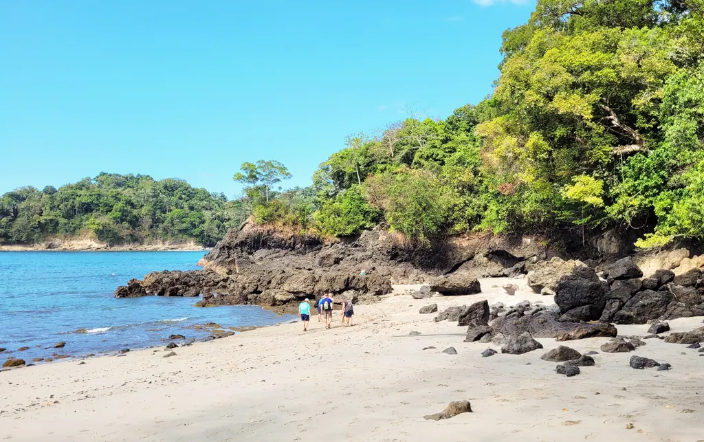 A quiet beach with rocks and rainforest inside Manuel Antonio National Park, Costa Rica