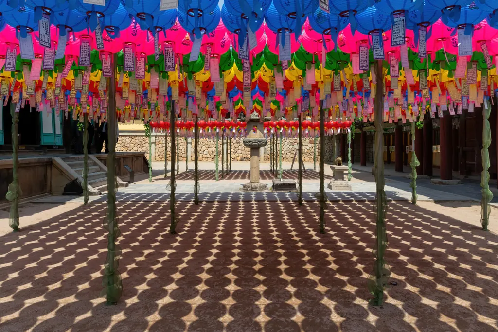 Hundreds of colorful paper lanterns hanging over a stone courtyard at Bulguksa temple in Gyeongju