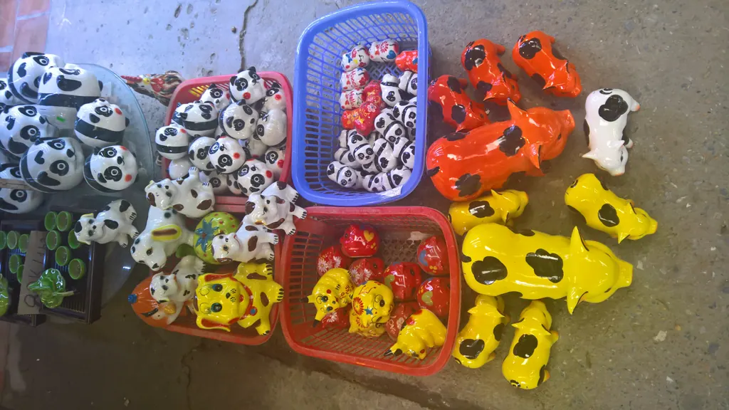 Brightly glazed ceramic animal figurines in baskets at a pottery shop in Bat Trang