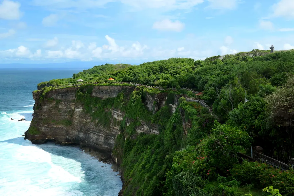 Green limestone cliffs and turquoise surf below the Uluwatu temple on the Bukit Peninsula in Bali