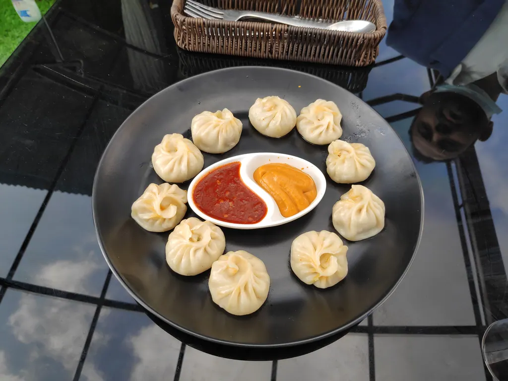 Momos with tomato and sesame dipping sauce, Nepal's favorite snack