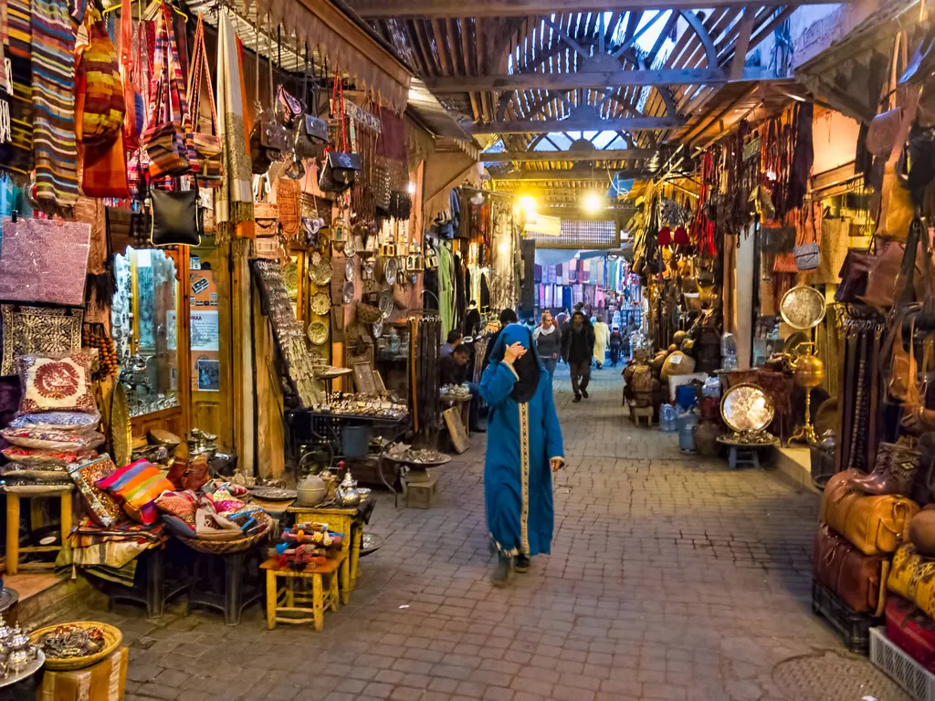 A covered souk in Marrakesh lined with lanterns, leather bags and textiles