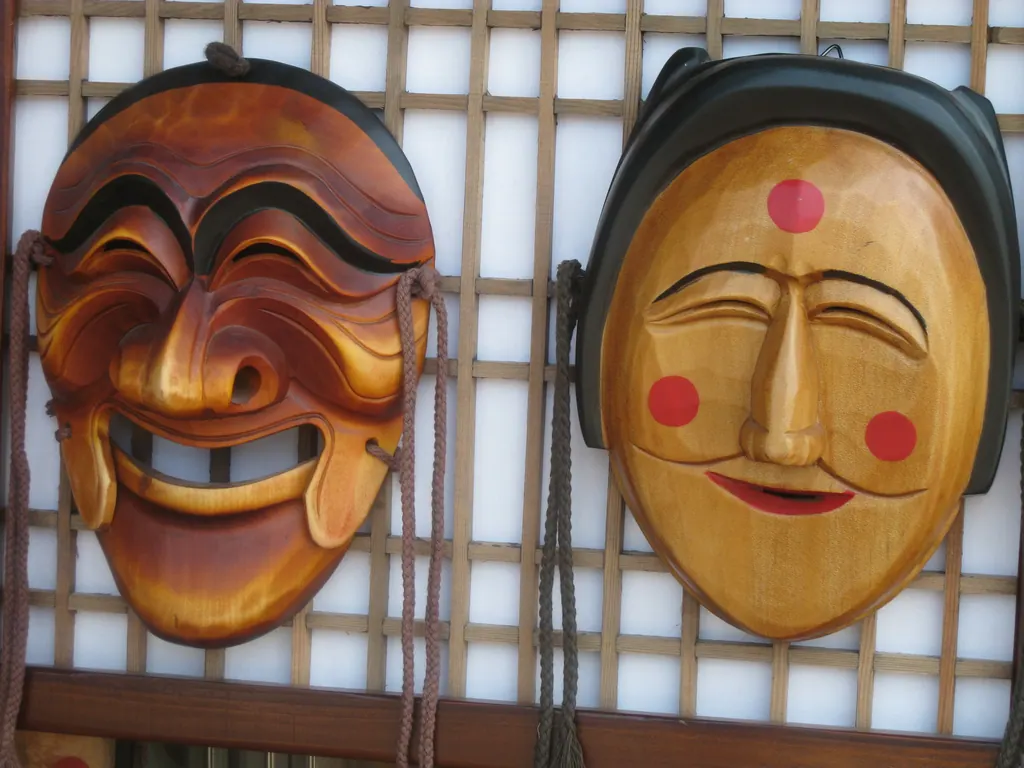 Two carved wooden Hahoe masks with painted faces hanging on a wooden lattice wall